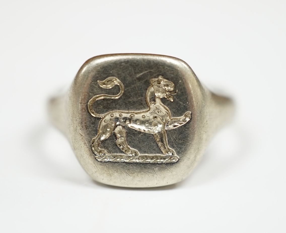 A George V 18ct white gold signet ring, carved with a crest, London, 1934, size I, 5.7 grams. Condition - fair